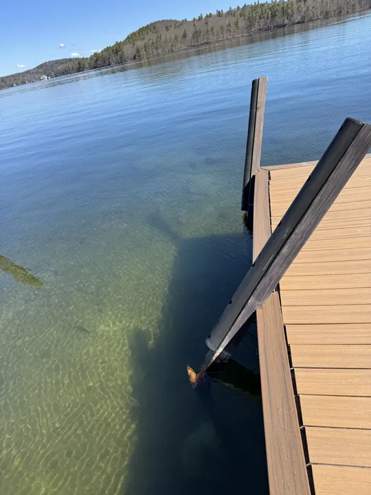 Broken timber post leaning beside the dock at the waterline