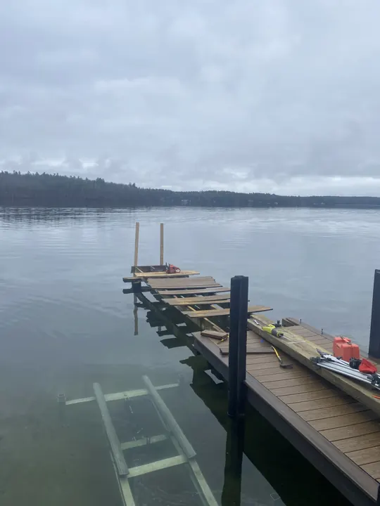 Partly opened composite dock with exposed framing over calm water