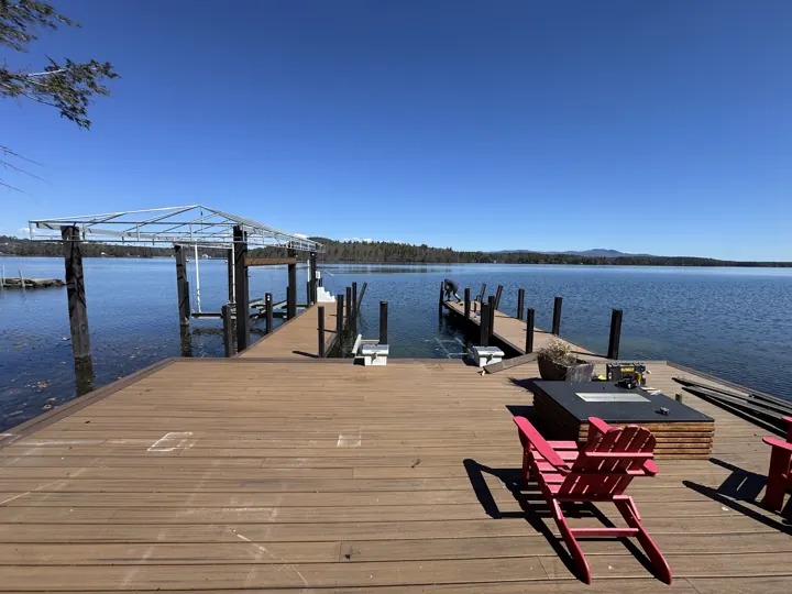 Dock repair in progress with tools on the deck and posts still leaning