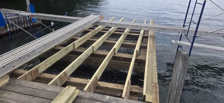 New timber stringers and cross-members over a crib dock, with staging alongside