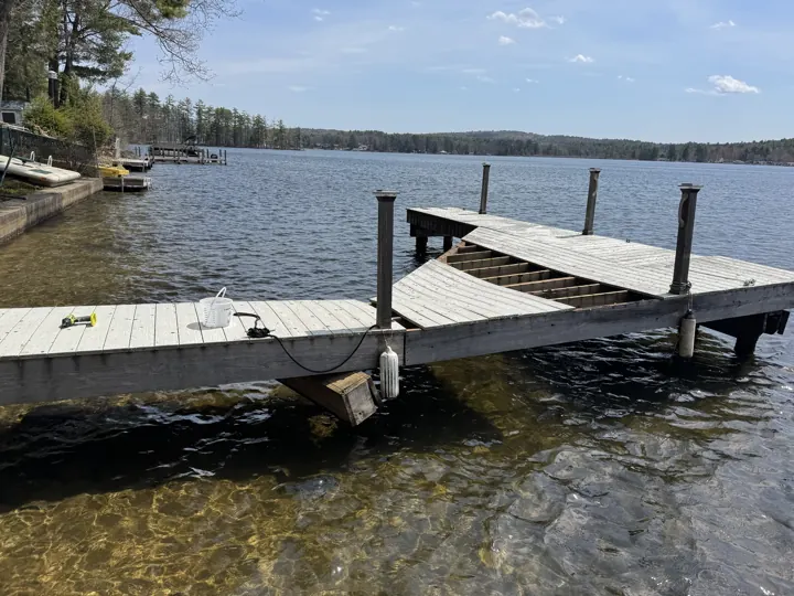Gray dock with a visibly sagging section and displaced decking