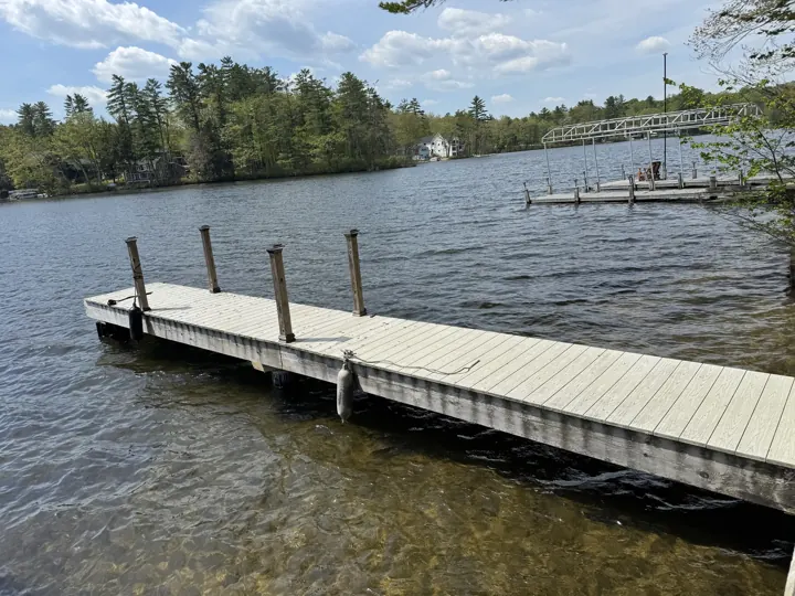 Repaired gray dock with continuous decking, new upright posts and hanging fenders