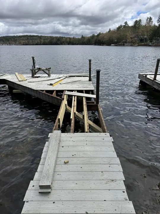 Opened gray dock viewed from the shoreline during structural repair