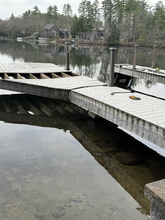 Split timber stringer beneath displaced gray dock decking