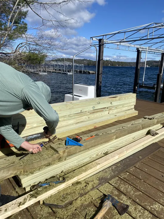 Worker using a chisel and hammer to fit new timber framing