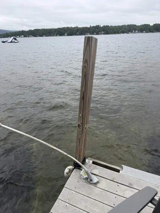 Weathered dock post and mooring hardware photographed close up