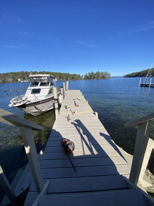 Boat dock with weathered posts and tools laid out before replacement work