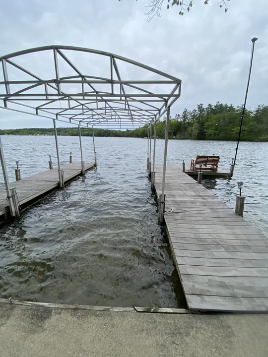 Gray dock and boat lift beside the shoreline approach