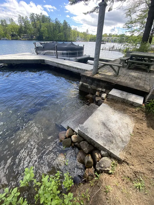 Granite steps meeting the water beside the dock and shoreline